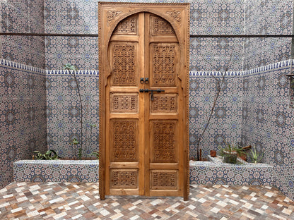 Light wood bedroom door, carved with wavy patterns, creating a calming and serene atmosphere.