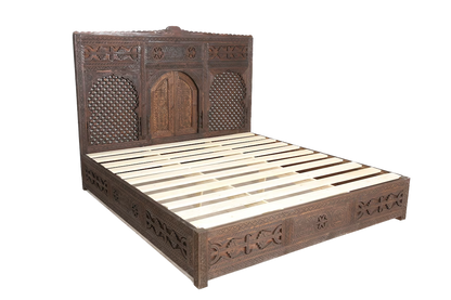 Intricate carved wooden bed frame in a traditional Moroccan style.
