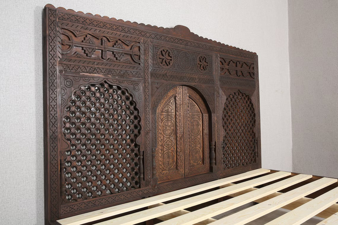 Handcrafted Moroccan-inspired wooden bed with a high headboard.
