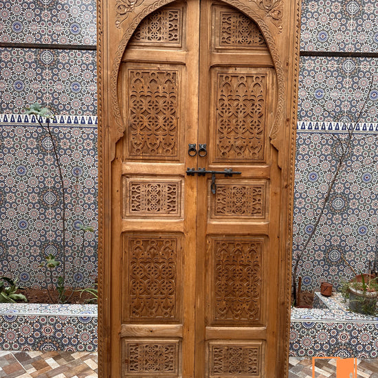Carved wooden partition, made up of individual door panels, creating an original and decorative screen.
