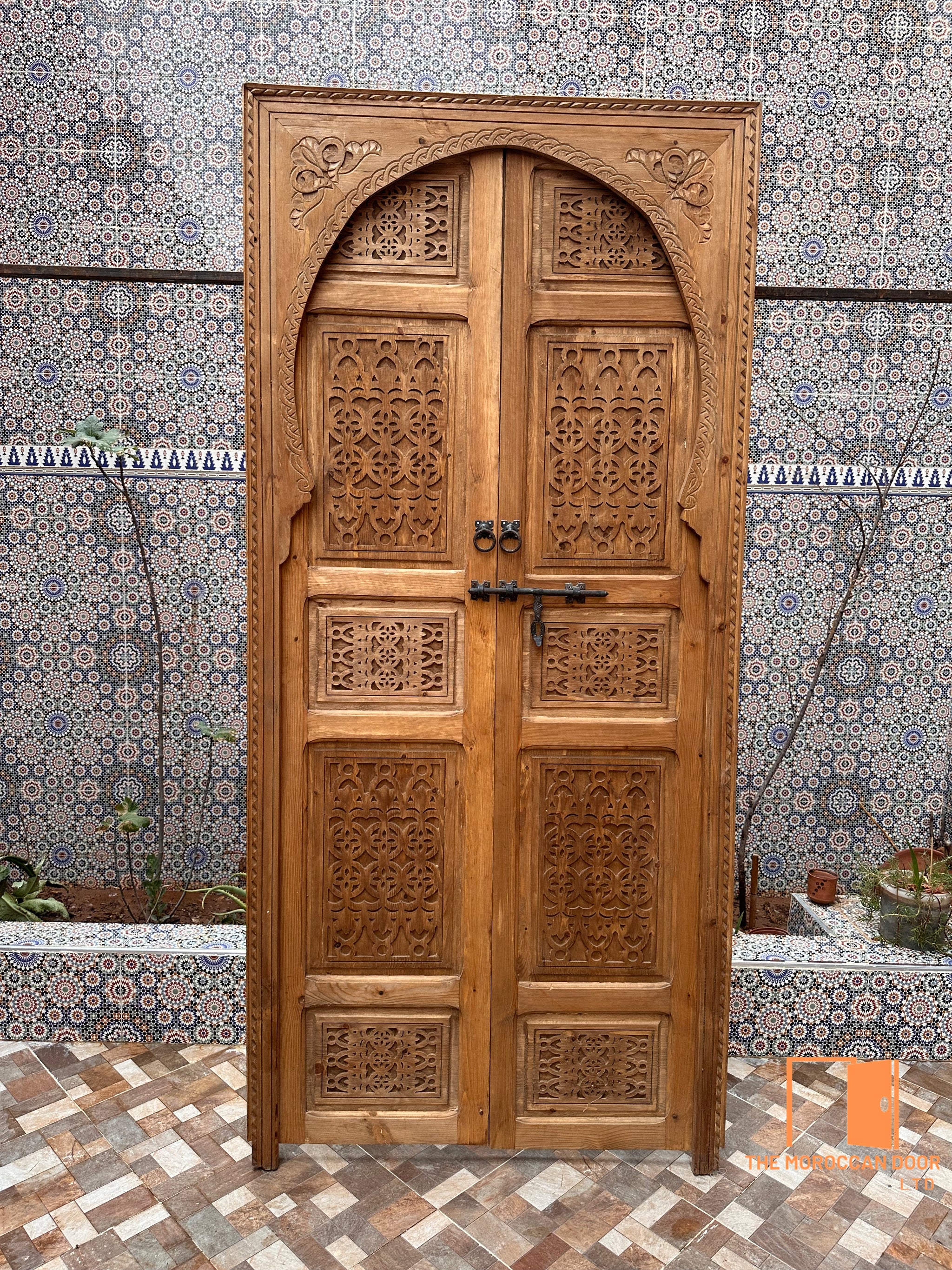 Carved wooden partition, made up of individual door panels, creating an original and decorative screen.