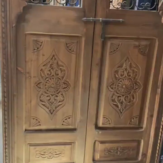 Porte marocaine traditionnelle Porte en bois sculptée , avec deux fenêtres en fer forgé travaillé a main . wall decor