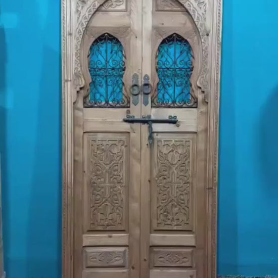 Traditional Moroccan door carved wooden door, with two windows in wrought iron worked a hand. wall decor.