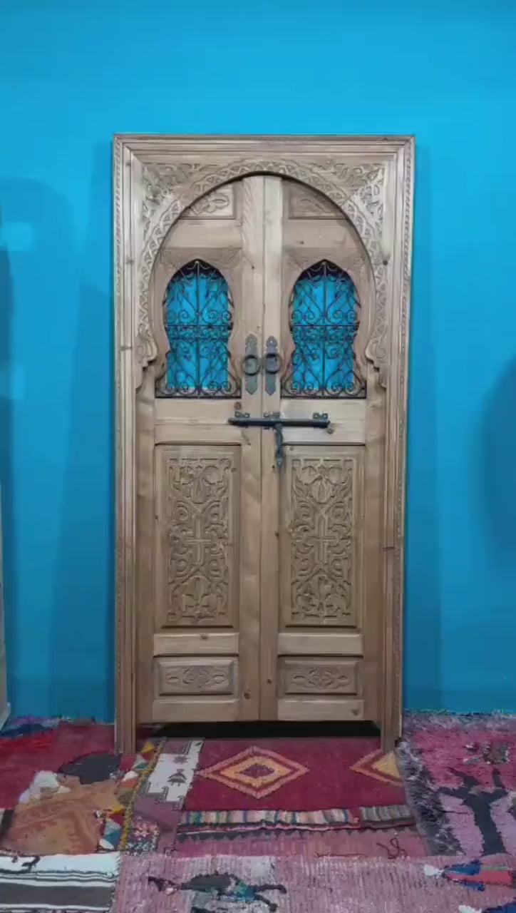 Traditional Moroccan door carved wooden door, with two windows in wrought iron worked a hand. wall decor.